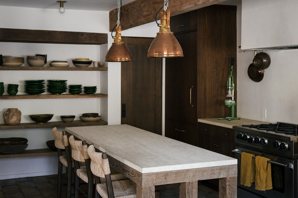 Móveis de madeira crua abraçam o conceito rústico abordado para o design de interiores desta cozinha — Foto: Rennie Solis