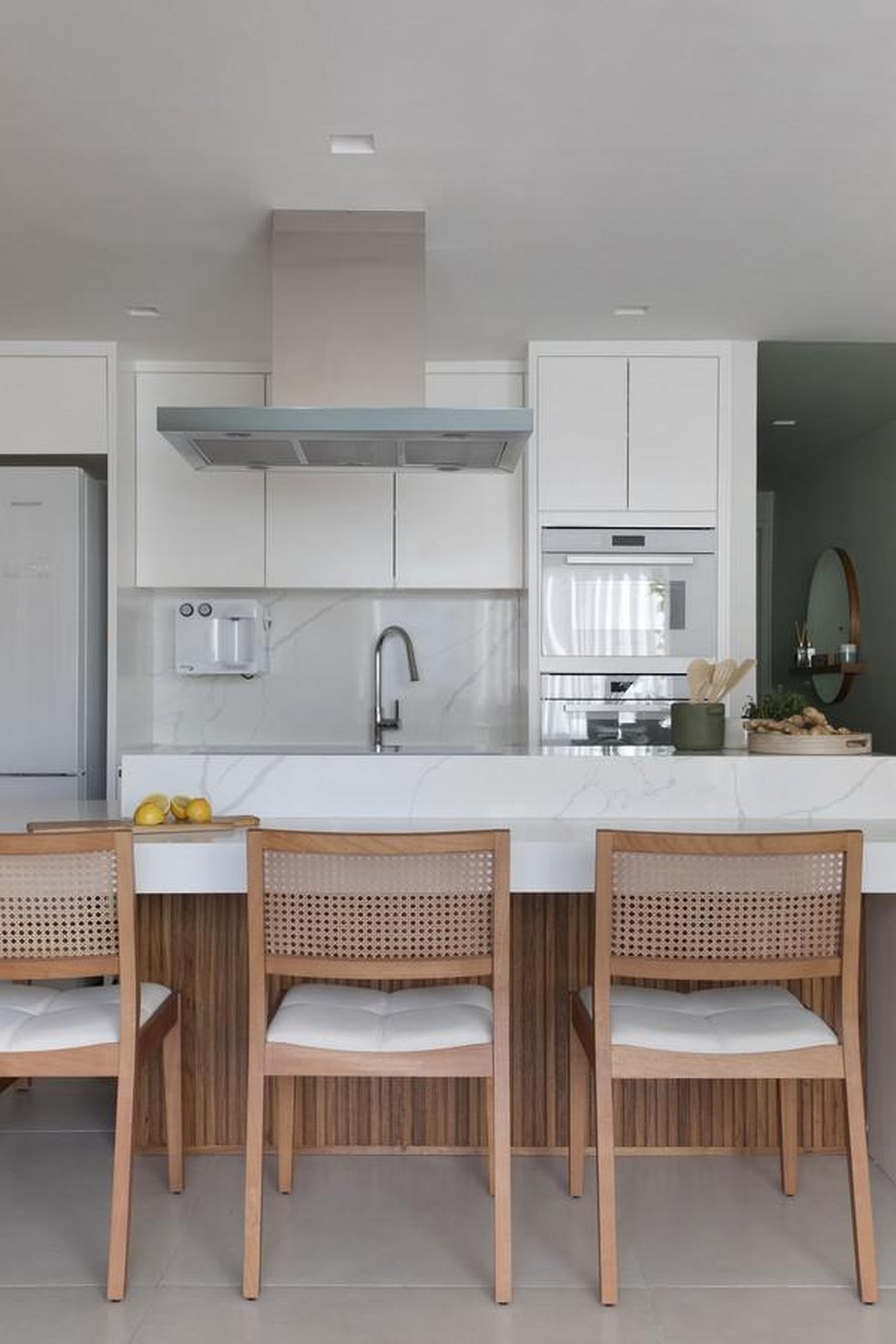 Um mesmo revestimento conecta a bancada de refeições à área molhada da cozinha (ao fundo) (Foto: Denilson Machado/MCA Estúdio) — Foto: Casa Vogue