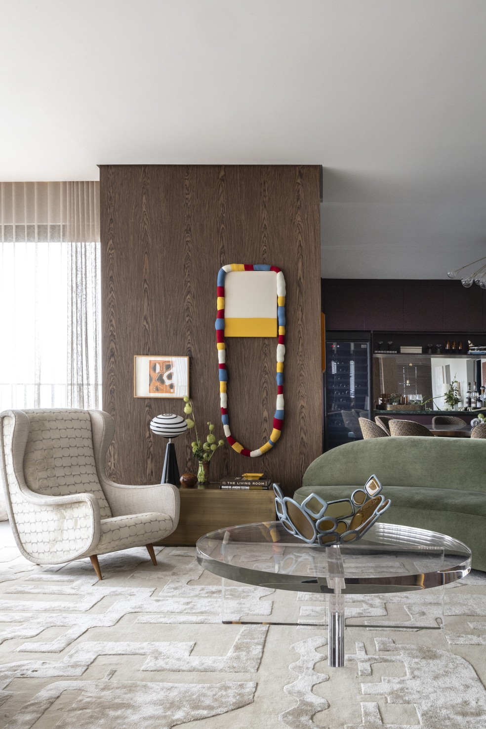 Poltrona de Marco Zanuso, garimpada na Galeria Teo e estofada com veludo e buclê da Safira Sedas, mesa de latão desenhada pelo escritório e executada pelo Designers Group, mesa de centro de acrílico desenhada pelo escritório e desenvolvida pela Léo Acrílicos, vaso de Lucas Recchia e luminária vintage garimpada na Legado Antiguidades, além de obras de Antonio Malta Campos e Yuli Yamagata — Foto: Ruy Teixeira