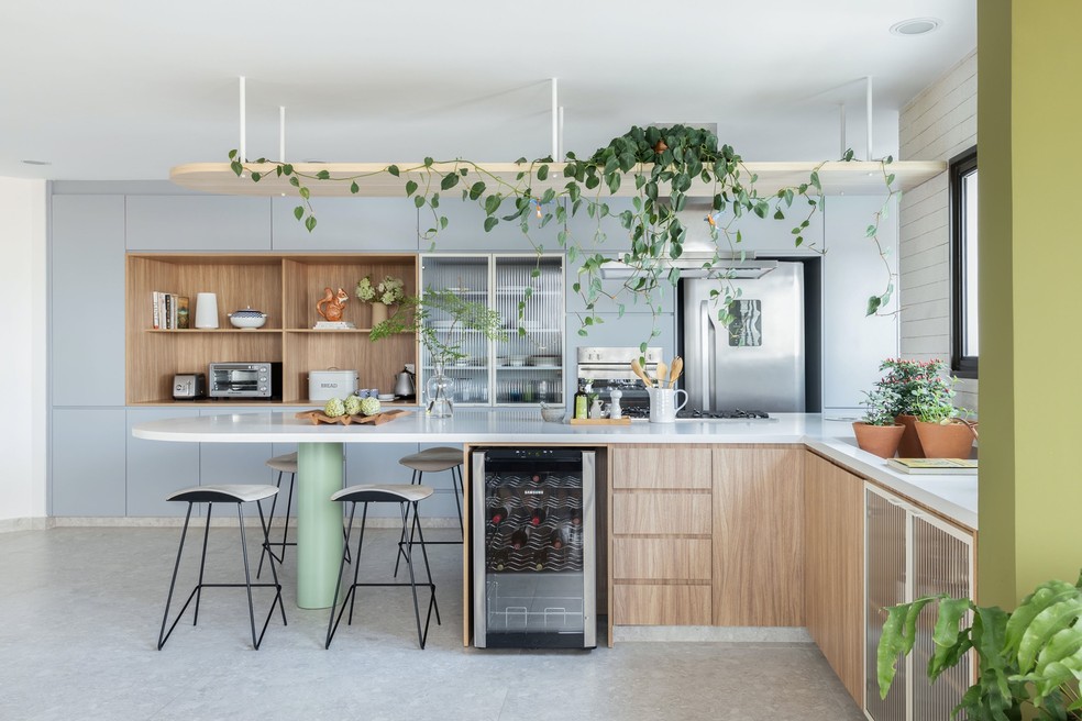Desenho minimalista, cores suaves e mix de materiais compõem o décor da cozinha — Foto: Maura Mello