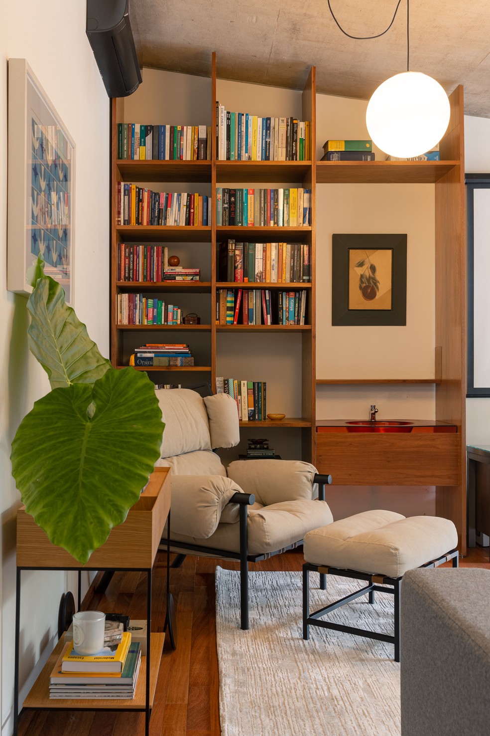 Em uma das salas íntimas, as arquitetas montaram um pequeno home office com biblioteca — Foto: Brenda Pontes