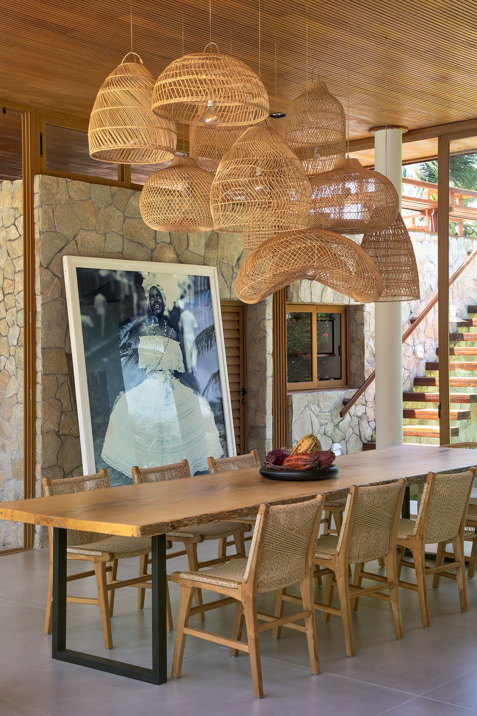A sala de jantar concentra dois elementos de impacto – o retrato da baiana, de J.R. Duran, e o cacho de luminárias de fibra, da Biasá — Foto: Ruy Teixeira