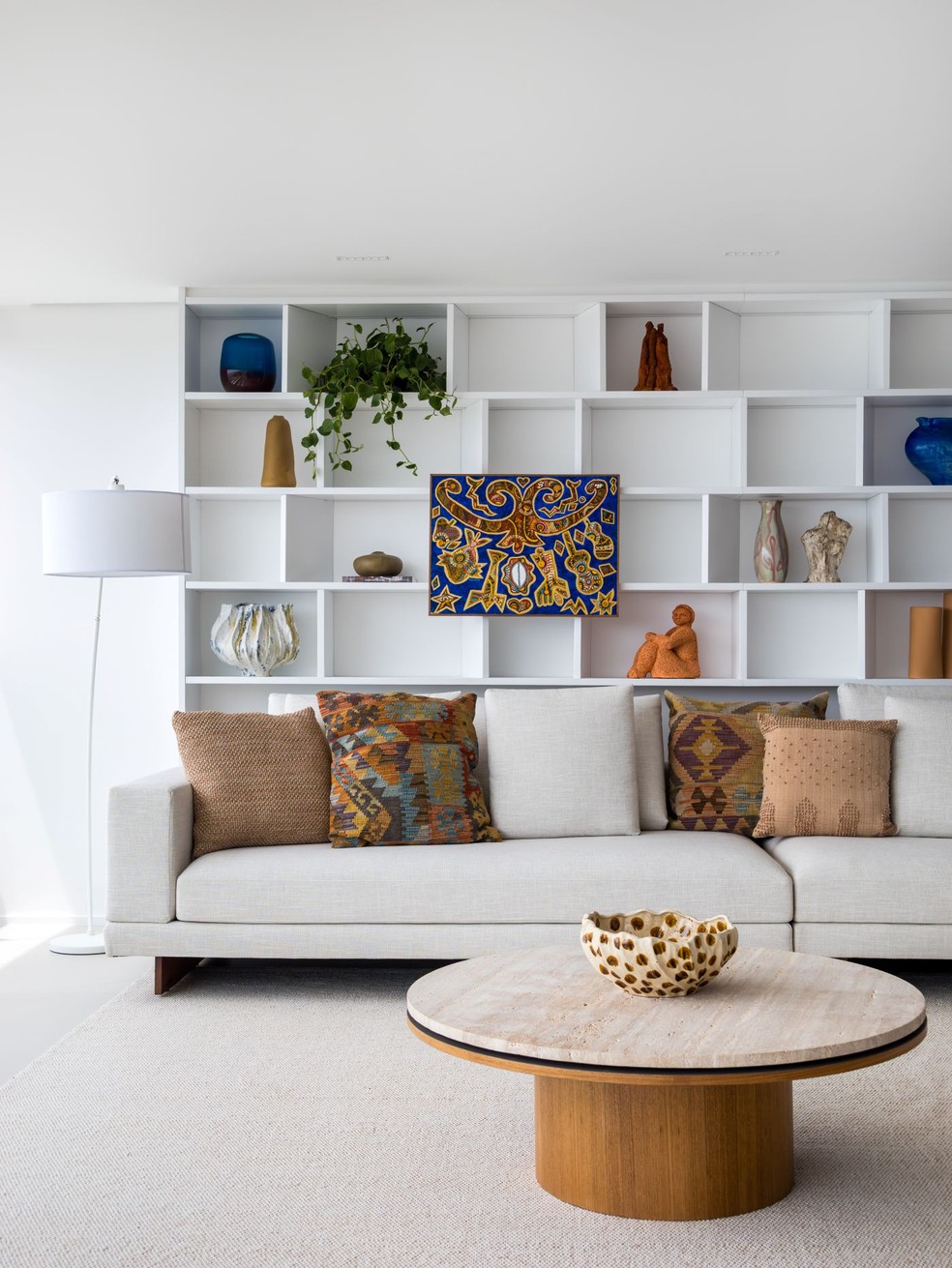 Desenhada pelo GAM Arquitetos, esta estante demonstra a necessidade de equilíbrio, com nichos vazios e outros dominados pelas peças decorativas — Foto: Paola Kiminami e Renato Rebouças/Divulgação