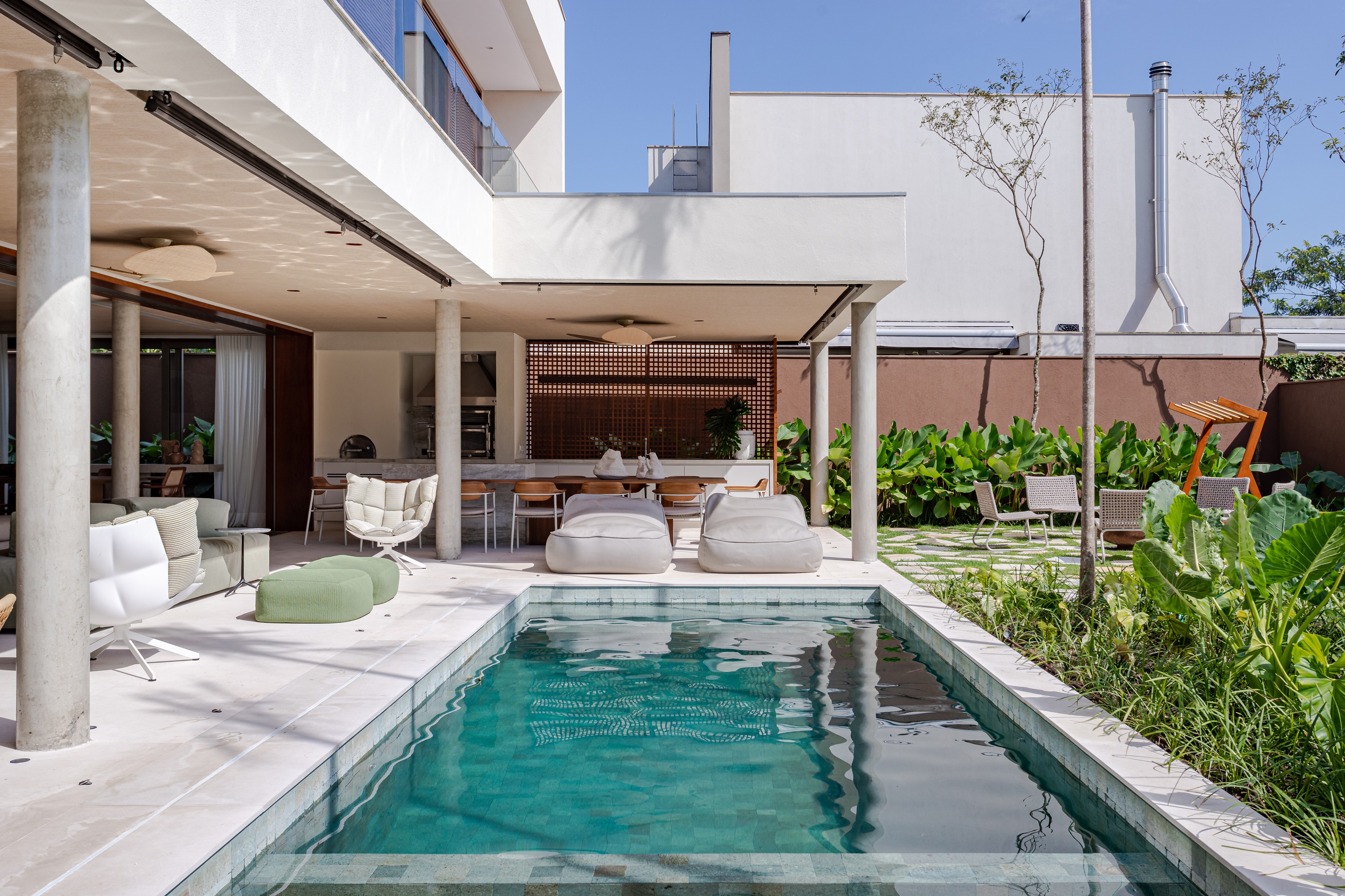 Casa de praia ganha varanda ampla e piscina em formato de raia após reforma