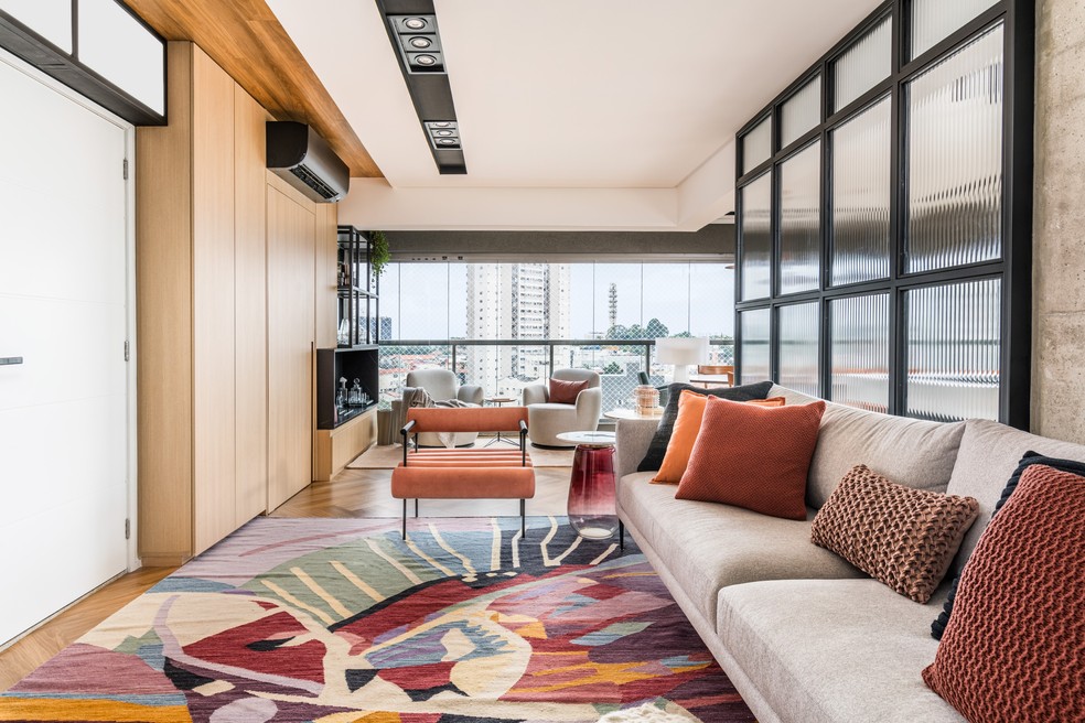 A poltrona Cilindros, de Murilo Weitz para Breton, garante charme extra ao living. As almofadas da Codex Home completam a paleta colorida — Foto: Renato Navarro