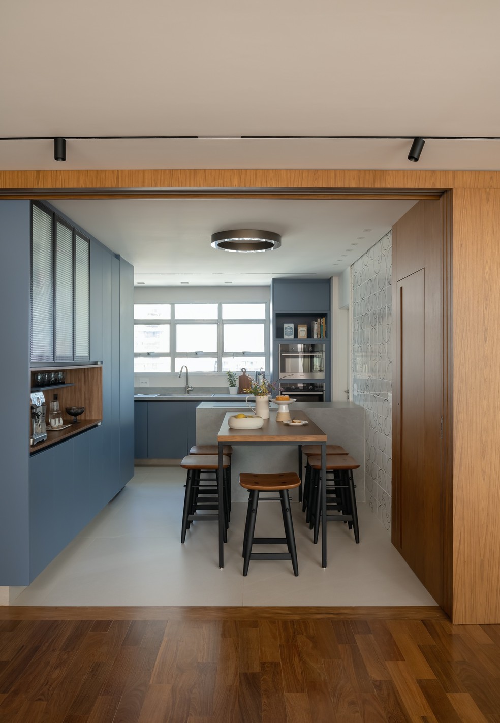 Na cozinha, predomina a cor azul, combinada com madeira para trazer um clima intimista — Foto: Cacá Bratke