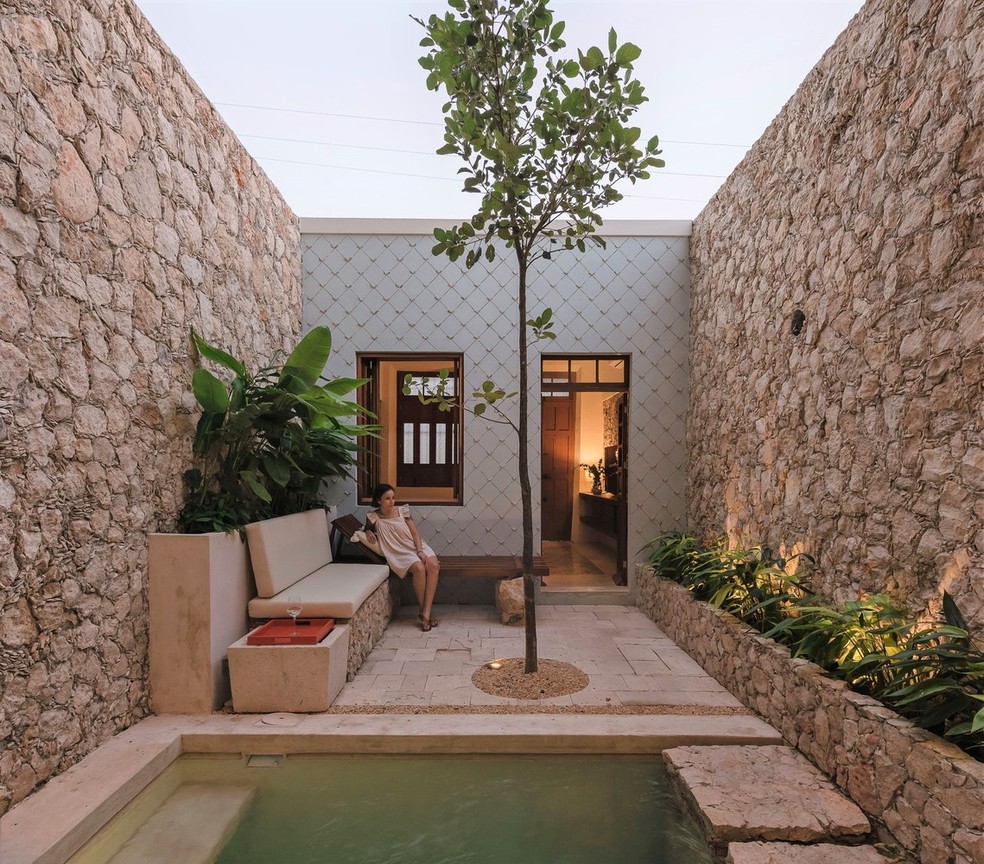Espaço com piscina e jardim conecta os dois anexos da casa — Foto: Tamara Uribe 
