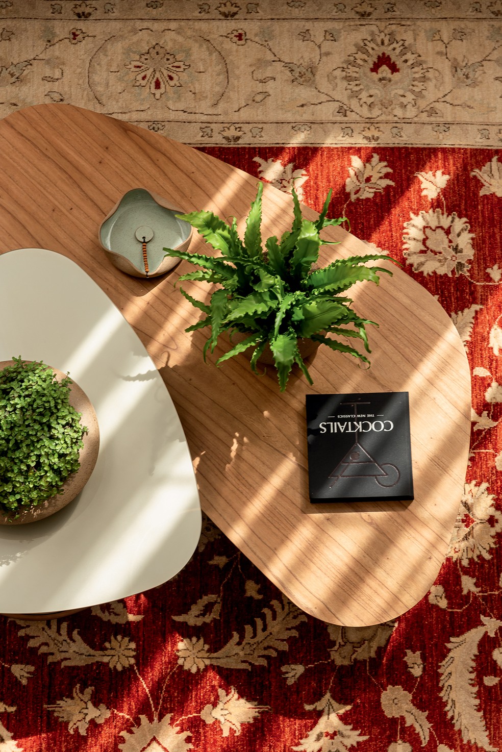 Detalhe da decoração do living, com dupla de mesas de centro de tonalidades neutras sobre o tapete Ziegler — Foto: Wesley Diego Emes