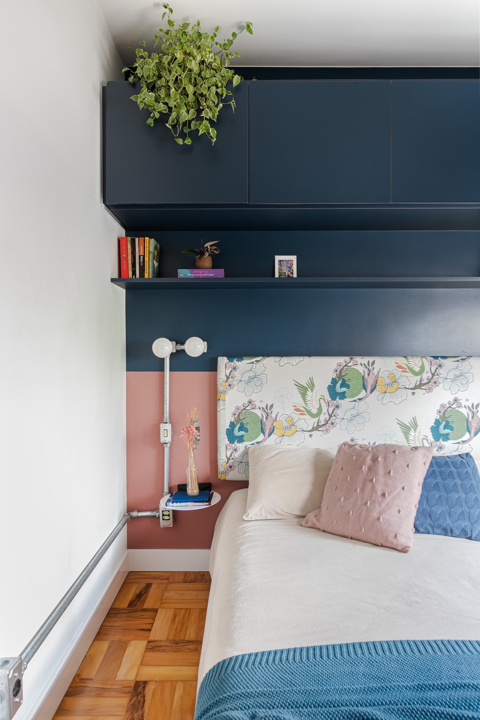 No quarto do casal, a marcenaria em tom de azul escuro ocupa meia parede sobre a cabeceira da cama — Foto: Gisele Rampazzo 