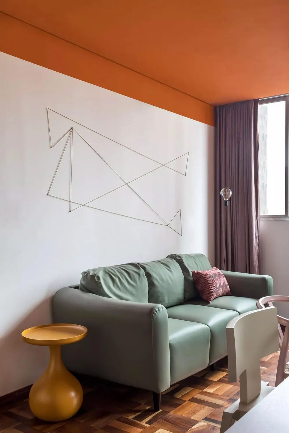 Esta sala de estar, assinada pelo Ohma Design, destaca-se com seu teto laranja — Foto: Eduardo Macarios
