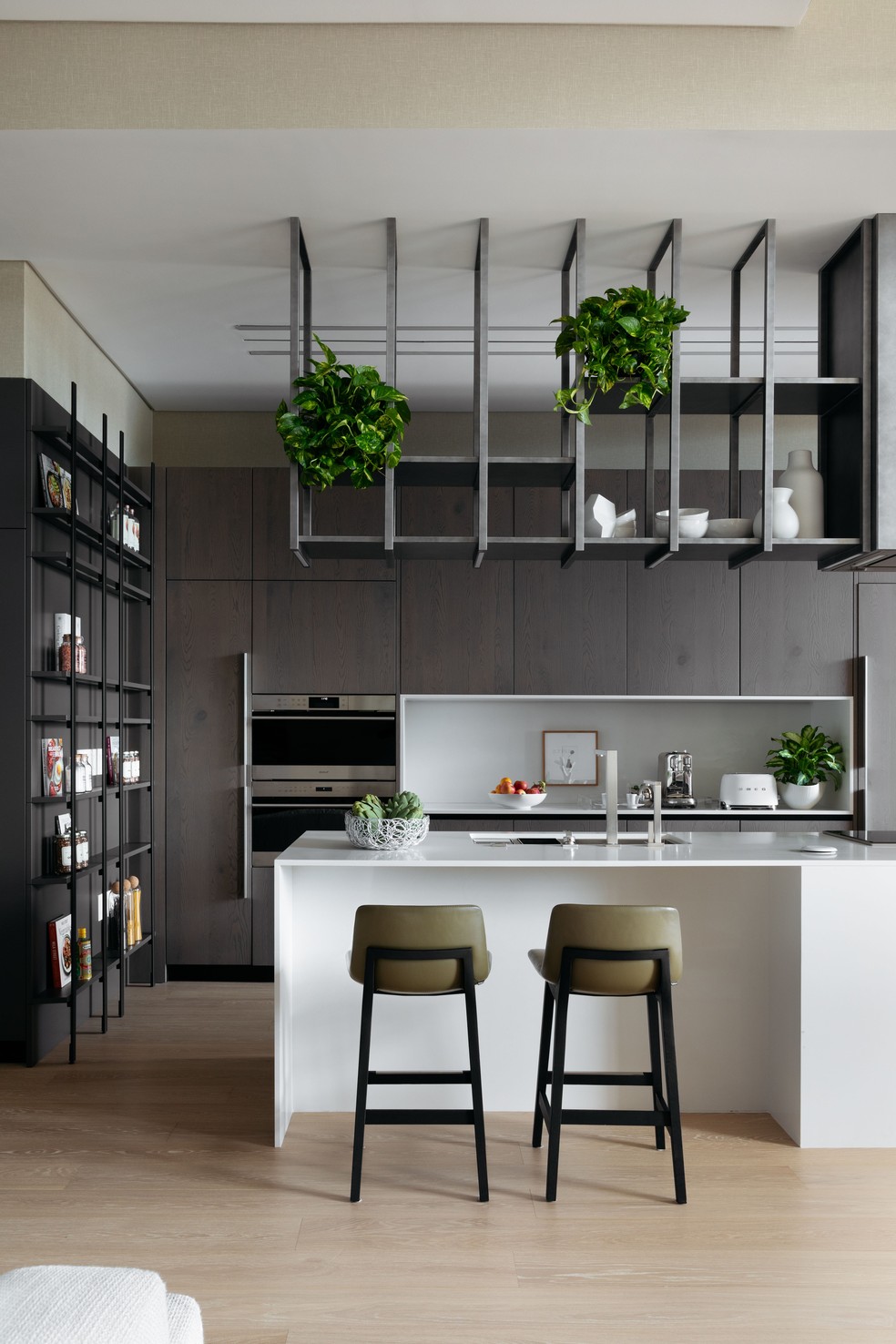 A cozinha aberta emoldura o estar, com tonalidades mais suaves — Foto: Denilson Machado/MCA Estúdio