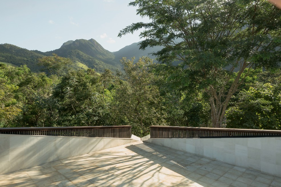 Na cobertura da casa, o terraço recebeu revestimento de pedra São Tomé e guarda-corpo de madeira itaúba com acabamento de serralheria — Foto: Federico Cairoli
