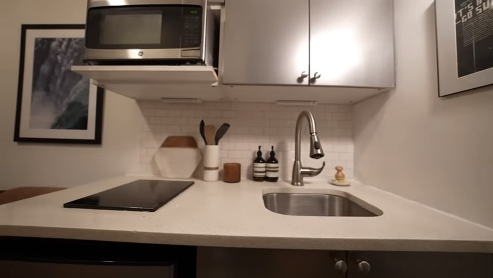 A cozinha é equipada com cooktop, mini-geladeira e uma pequena pia — Foto: Reprodução/YouTube @CALEBWSIMPSON