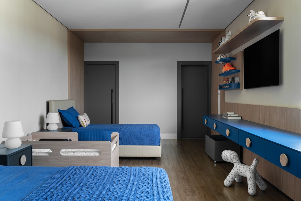 O quarto das crianças exibe detalhes (roupa de cama e marcenaria) em azul quebrando a sobriedade do restante do projeto — Foto: Estúdio NY18