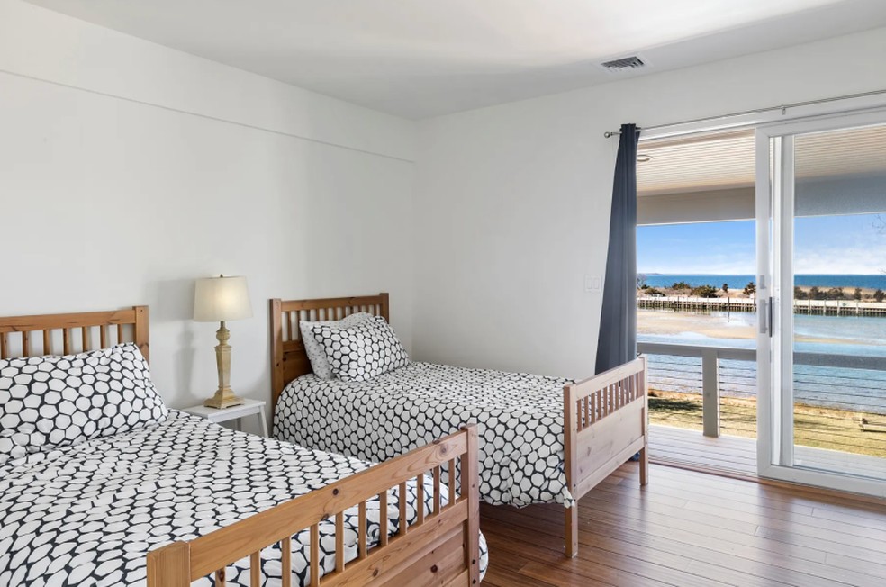 Este quarto conta com duas camas de solteiro e acesso ao deck — Foto: Divulgação