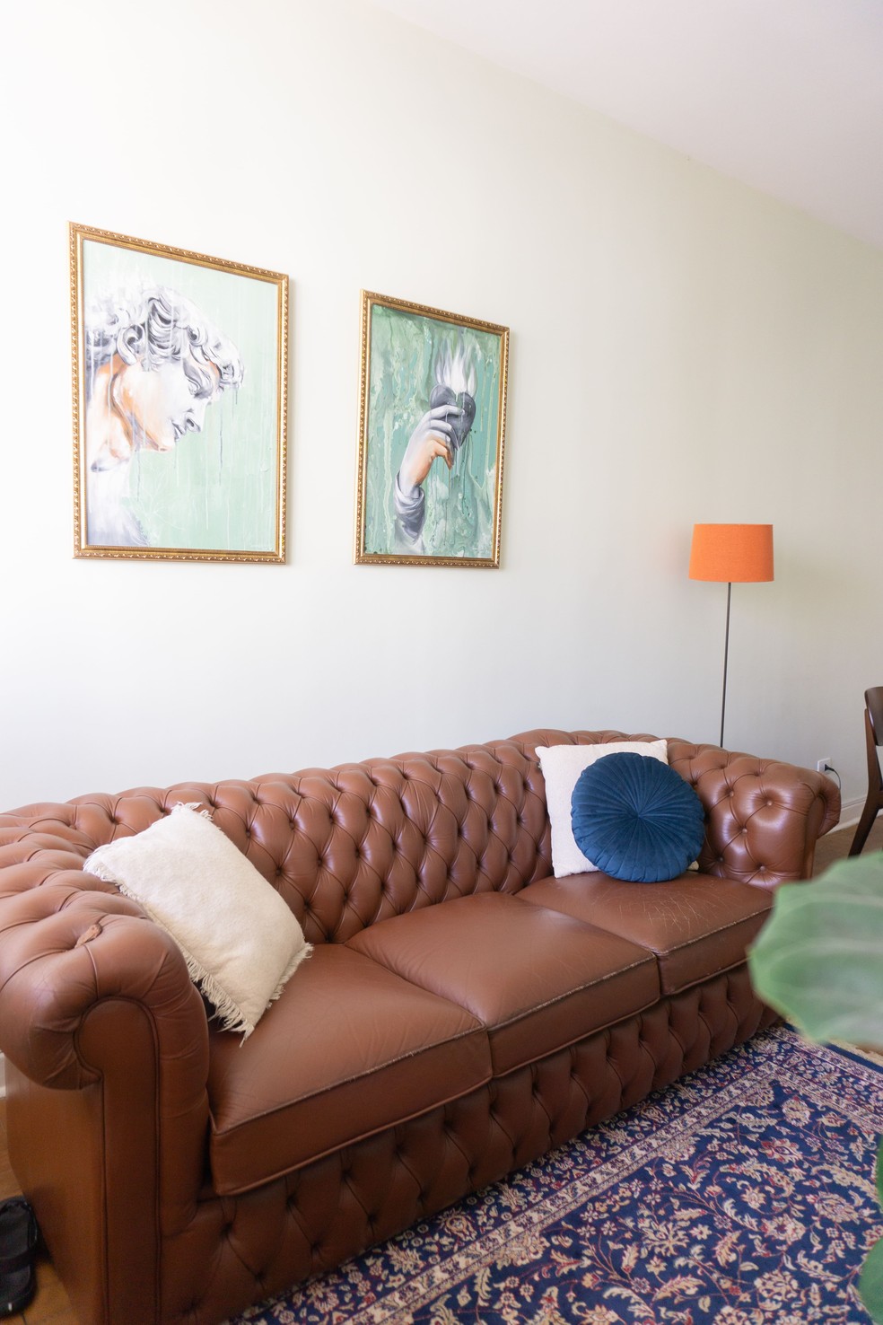 Dois quadros e um tapete estampado enfeitam a sala do apartamento — Foto: Divulgação