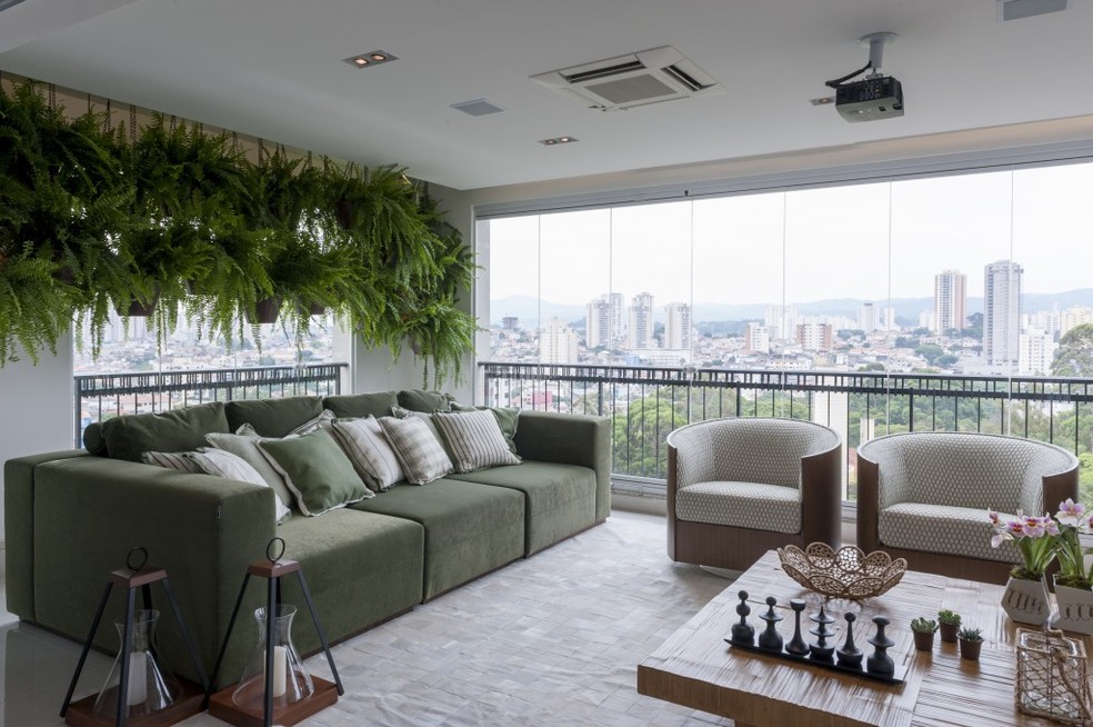 Nesta varanda gourmet, a arquiteta Cristiane Schiavoni optou por um sofá verde — Foto: Raul Fonseca