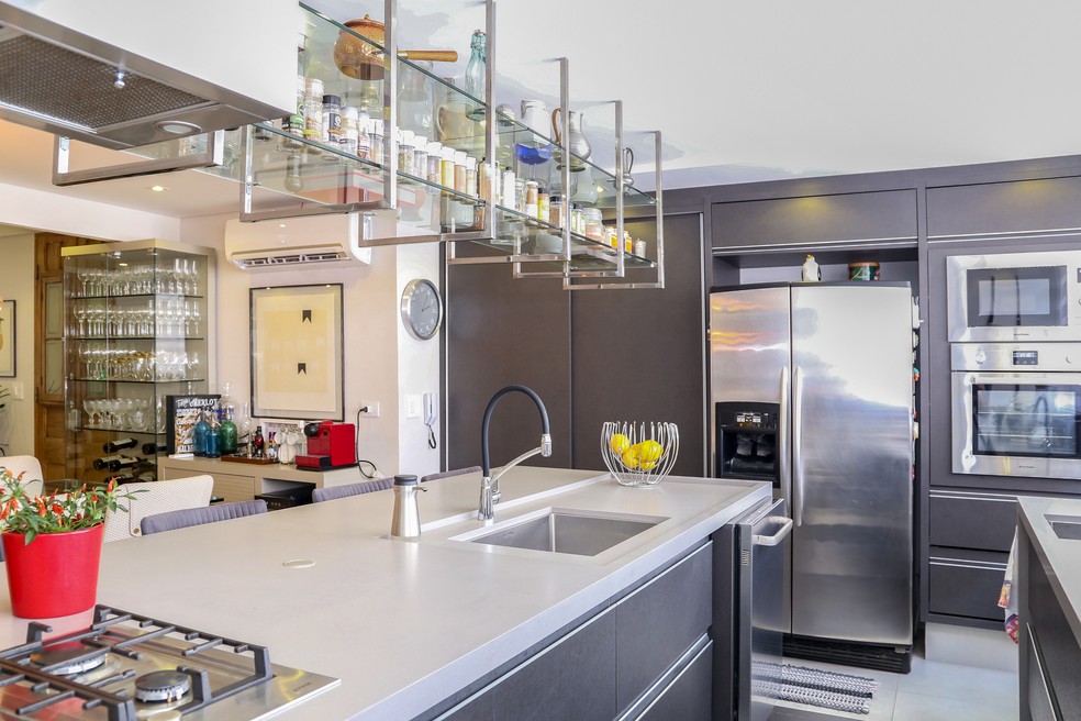 Em uma cozinha bem equipada, como neste projeto de Meneghisso & Pasquotto Arquitetura, é importante checar as instalações elétricas antes de viajar. Além disso, vale desligar os eletrodomésticos da tomada — Foto: Divulgação