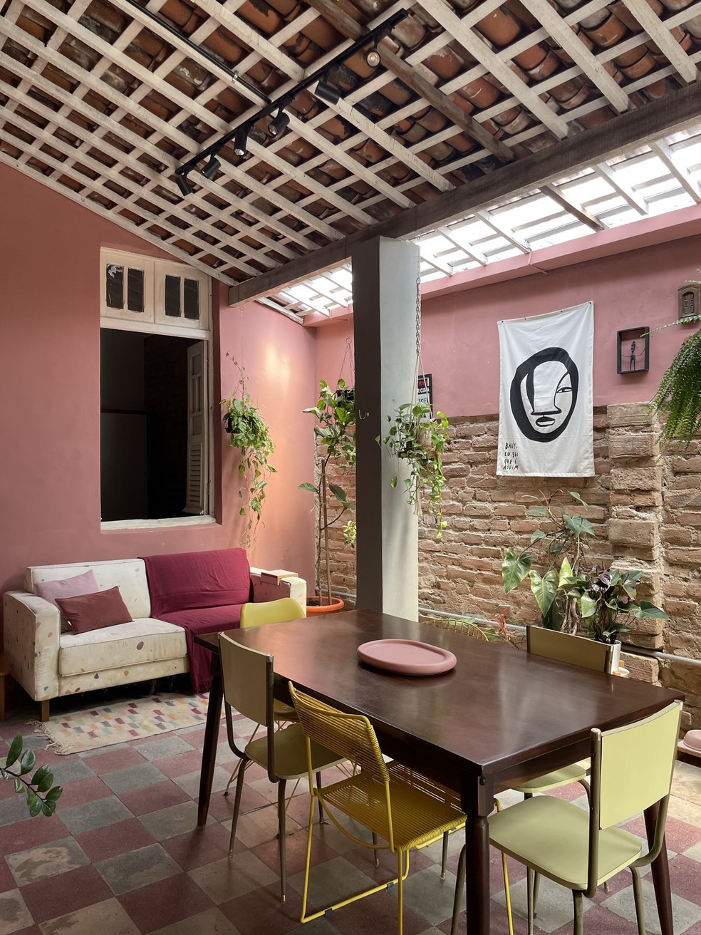 Esta área da casa ganhou um sofá e mesa de jantar, além de telhas translúcidas  — Foto: Karla Burlamaqui
