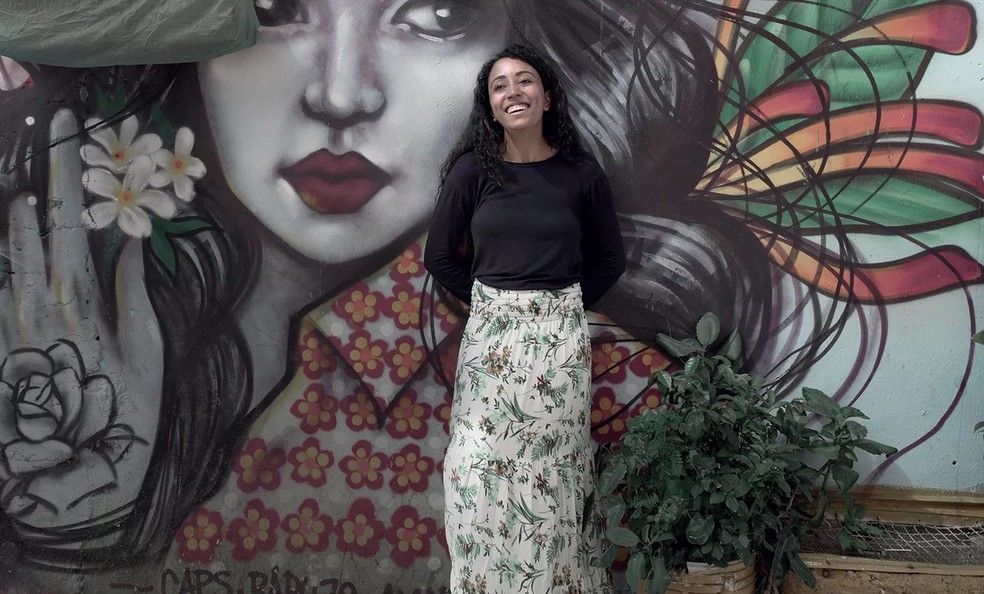 Ester posa em frente a um grafite no Jardim Colombo — Foto: divulgação