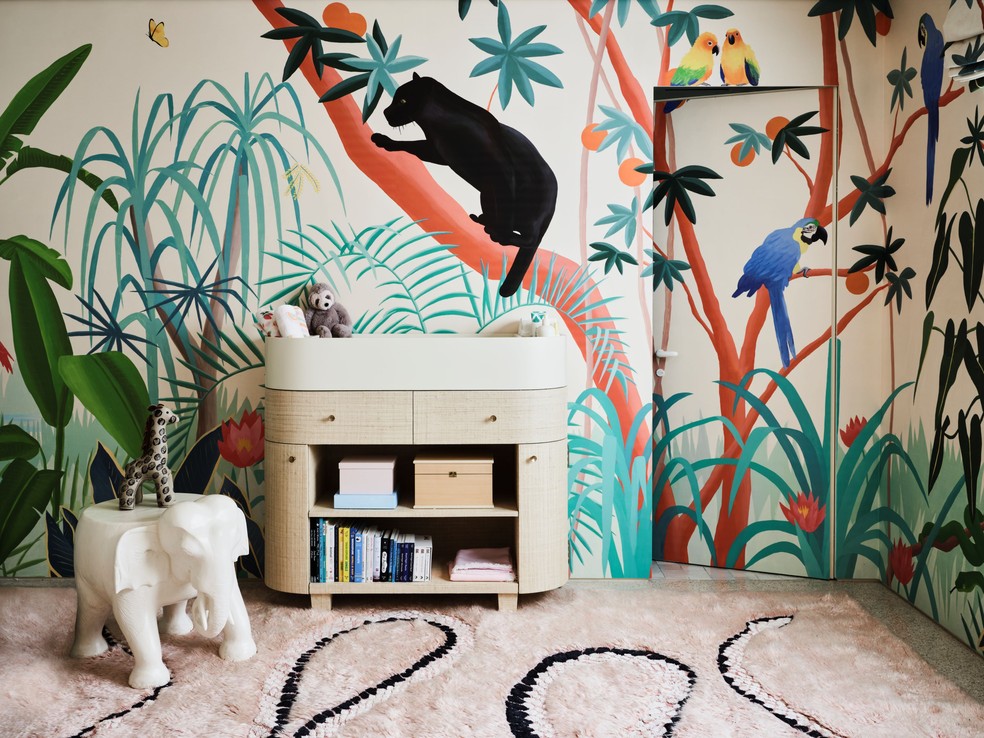 Um mural de selva de Liesel Plambeck envolve o quarto de bebê e, sobre o piso, tapete Ano da Cobra, de Liesel Plambeck para a Mehraban. — Foto: Douglas Friedman