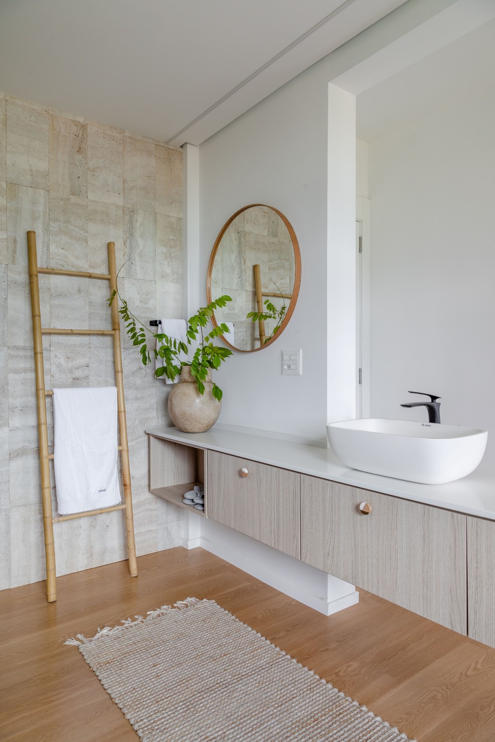 O banheiro da suíte conta com piso de madeira e revestimento de pedra nas paredes  — Foto: Fábio Jr Severo