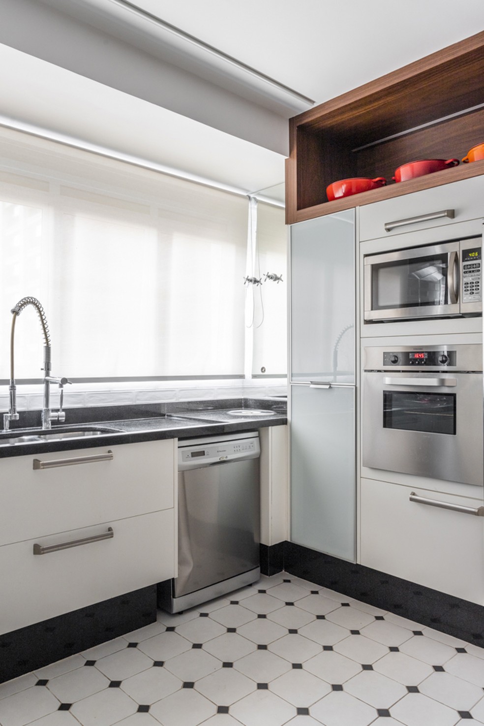 Mais um ângulo da cozinha, com eletrodomésticos embutidos na marcenaria planejada — Foto: Thiago Travesso