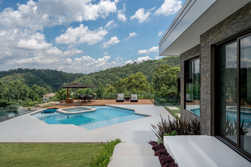 Uma vasta e densa área verde nos arredores emoldura a casa – para que os moradores pudessem contemplá-la livremente, a concepção do projeto partiu da integração dos ambientes internos e externos, viabilizada por grandes vãos envidraçados com caixilhos da Weiku do Brasil — Foto: Favaro Jr./divulgação