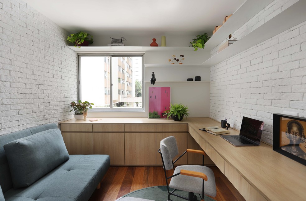 No home office, a marcenaria planejada define a estação de trabalho. O cômodo também pode ser usado como quarto de hóspedes — Foto: Mariana Orsi