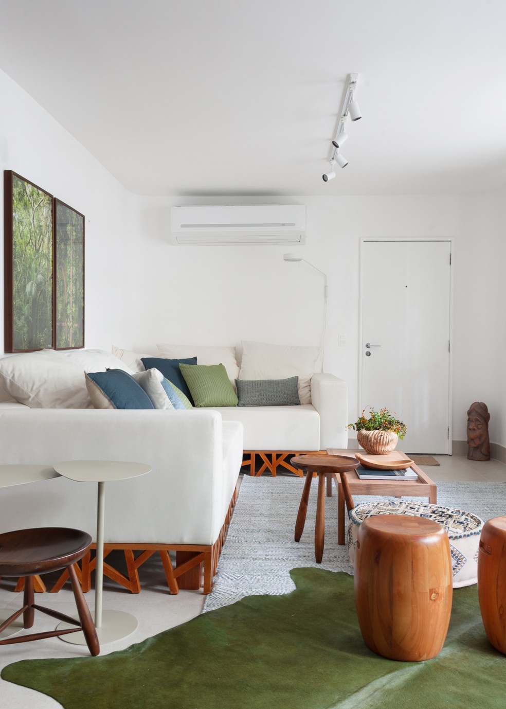 Sala de estar ganhou móveis em madeira, que constratam com o tom de verde escolhido para a decoração, como no tapete — Foto: Leonardo Olicos