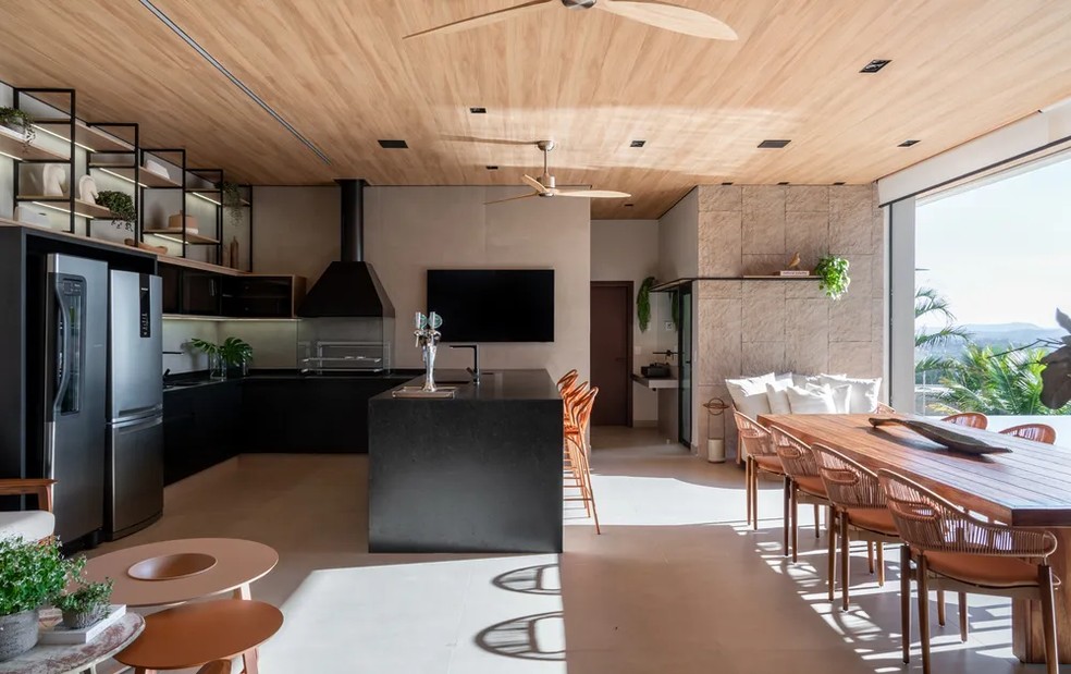 Nesta área gourmet, a arquiteta Danielle Spadoni investiu no uso de madeira para trazer aconchego  — Foto: Fávaro Junior