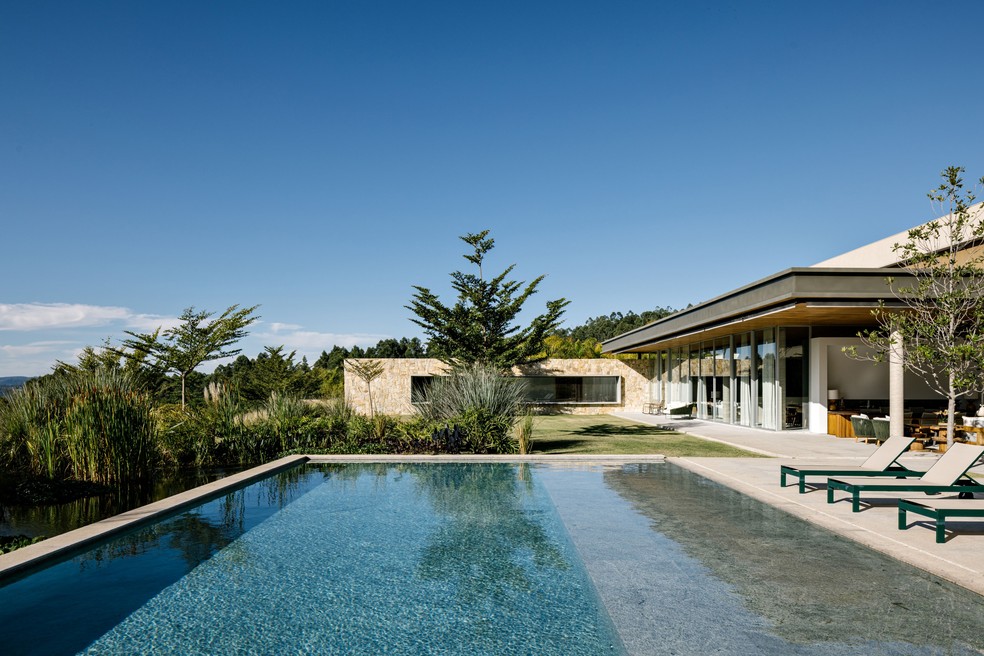 Conectada com a área gourmet, a piscina é envolvida pelo jardim, com paisagismo de Renata Tilli e Juliana do Val, do Gaia Projetos  — Foto: Fran Parente 