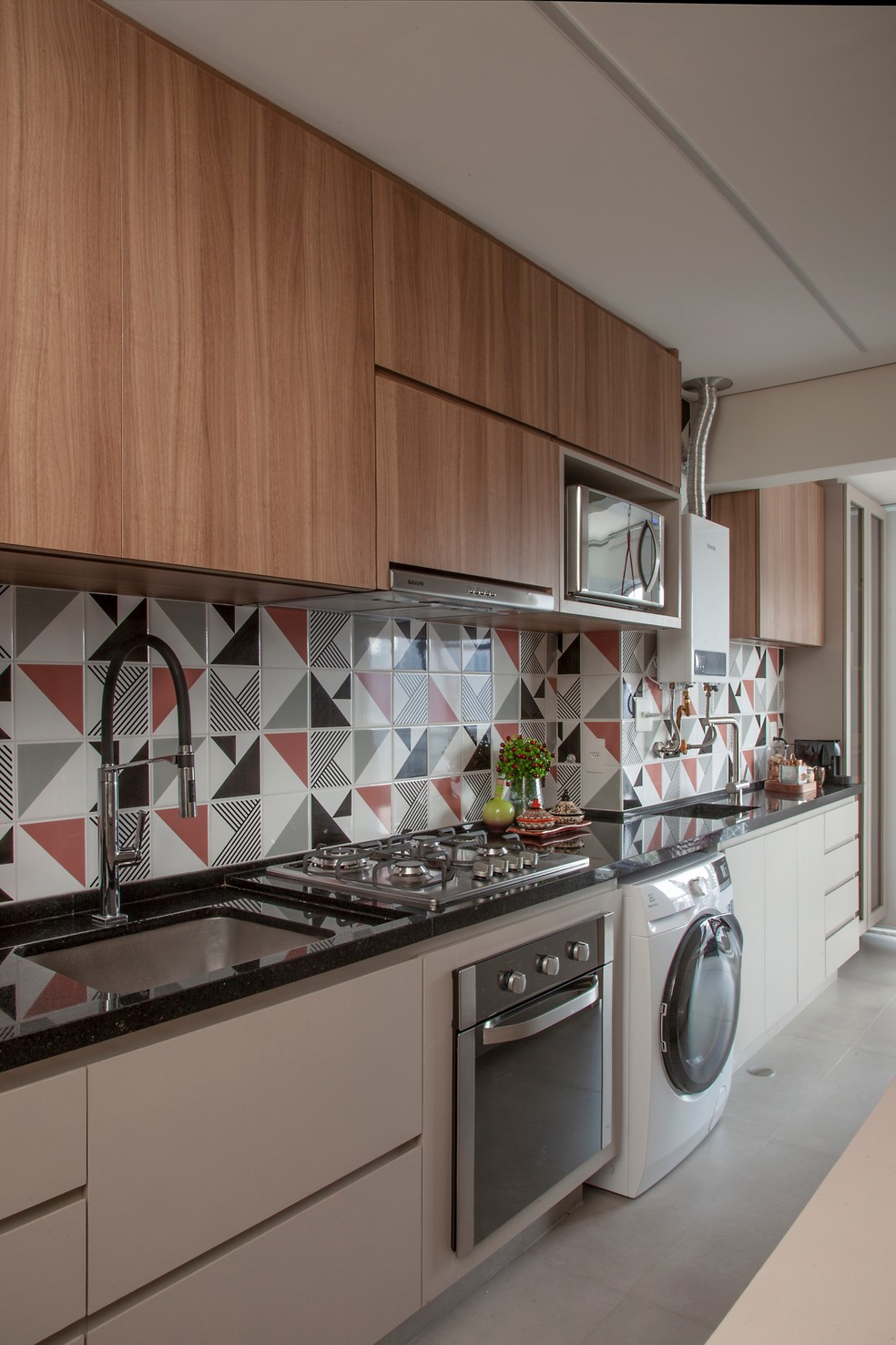 Eletrodomésticos embutidos, como o fogão nesta cozinha projetada pelo Studio Tan-gram, ajuda a otimizar o espaço — Foto: Luis Gomes