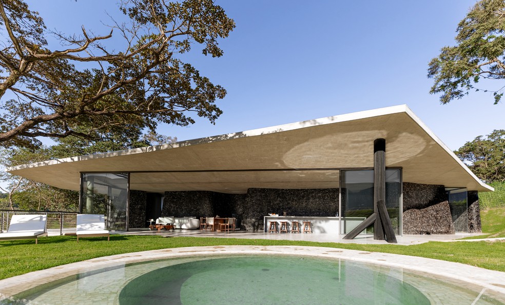 Vista da residência aberta a partir da área de lazer e da piscina  — Foto: Luisa Lage