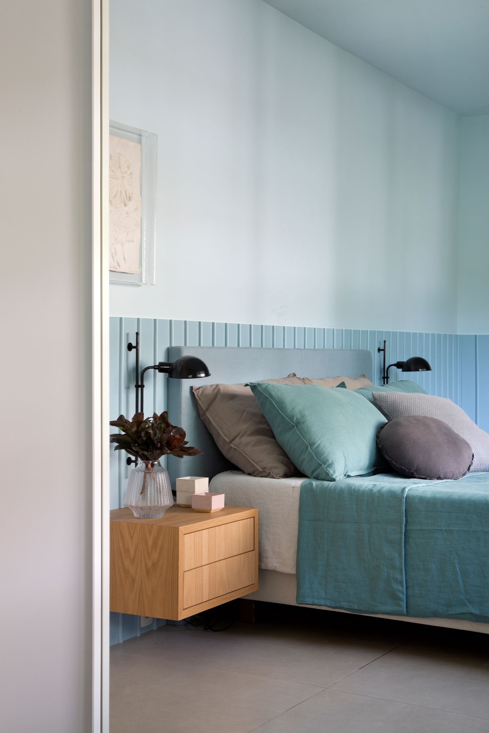 No quarto de casal, o painel ripado foi pintado de azul e emoldura a cabeceira estofada da cama — Foto: Denilson Machado/MCA Estúdio