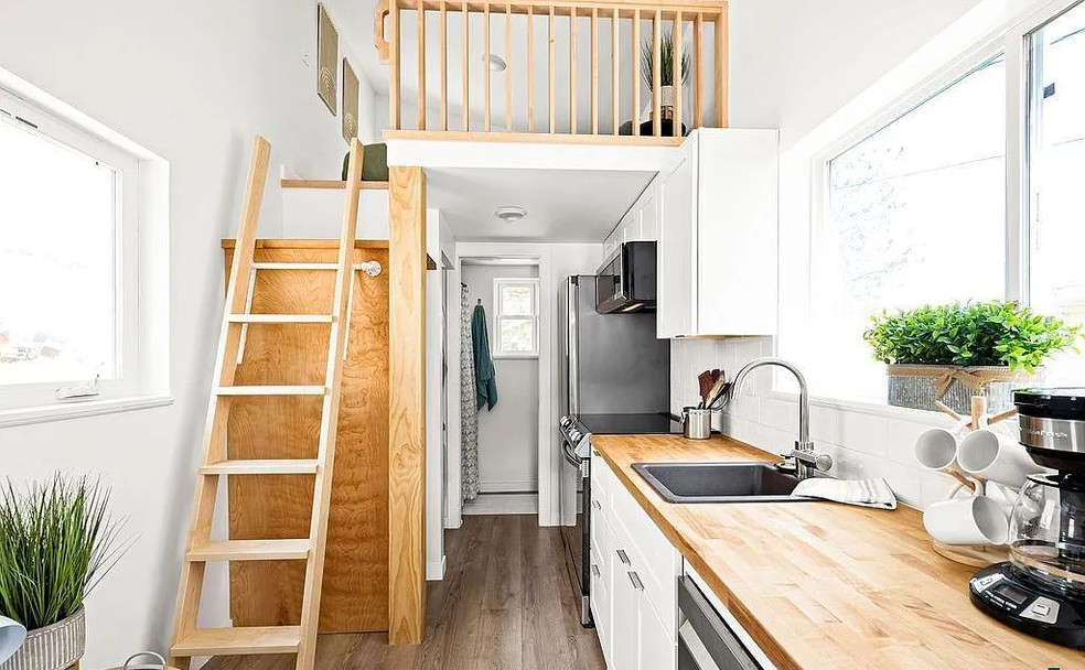 Cozinha anexada com a lavanderia e escada para o segundo andar com quarto  — Foto: Divulgação