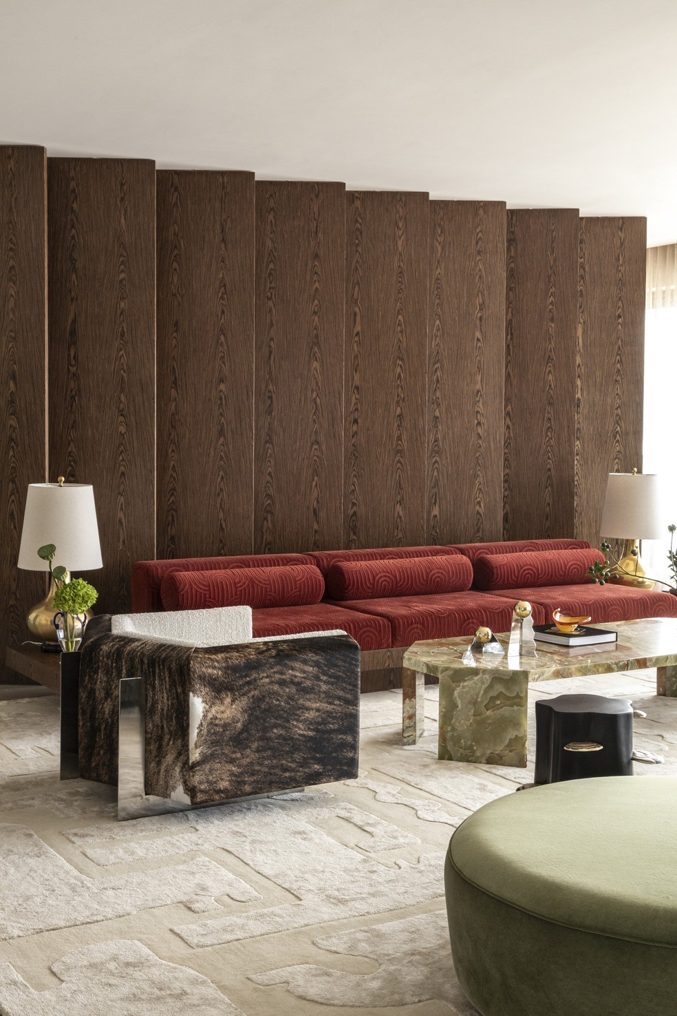 Sofá da Paschoal Ambrosio com veludo da Safira Sedas, poltrona da Mobília Puro para o Designers Group, mesa de centro de ônix desenhada pelo escritório, tapete de lã e seda desenvolvido na Índia pela By Kamy, e luminárias douradas da Dominici, garimpadas no Thomaz Saavedra — Foto: Ruy Teixeira