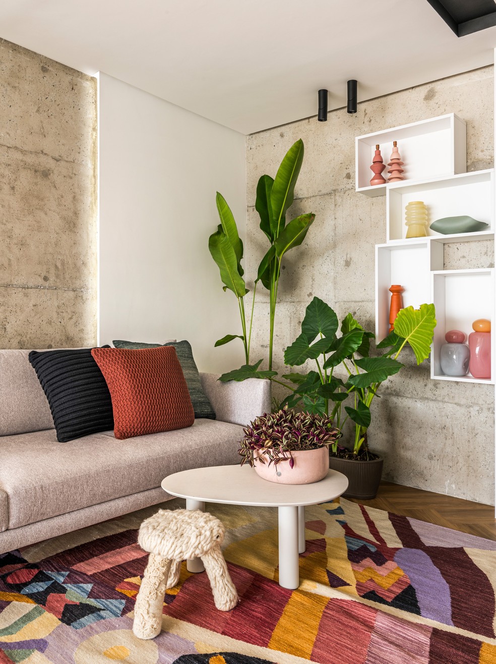 O detalhe do living exibe estruturas originais de concreto, que foram expostas após a remoção do reboco e garantem personalidade ao projeto. O banquinho em primeiro plano é da loja Black Angel — Foto: Renato Navarro