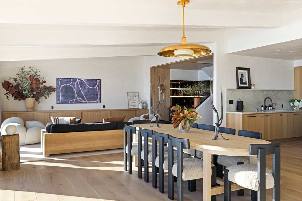 Sala de jantar fica centralizada no ambiente, ao lado dos dois ambientes de estar na área social — Foto: Alexis Adams