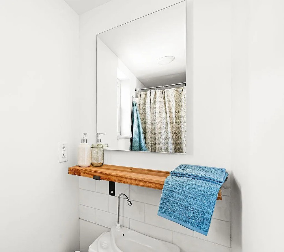 Banheiro pequeno, com chuveiro com box de cortina e pia  — Foto: Divulgação
