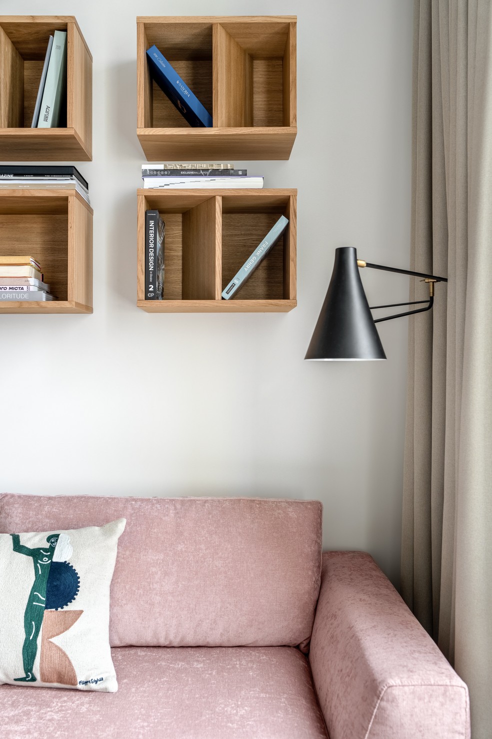 Detalhe do living com sofá rosa e nichos organizadores — Foto: Andrey Bezuglov