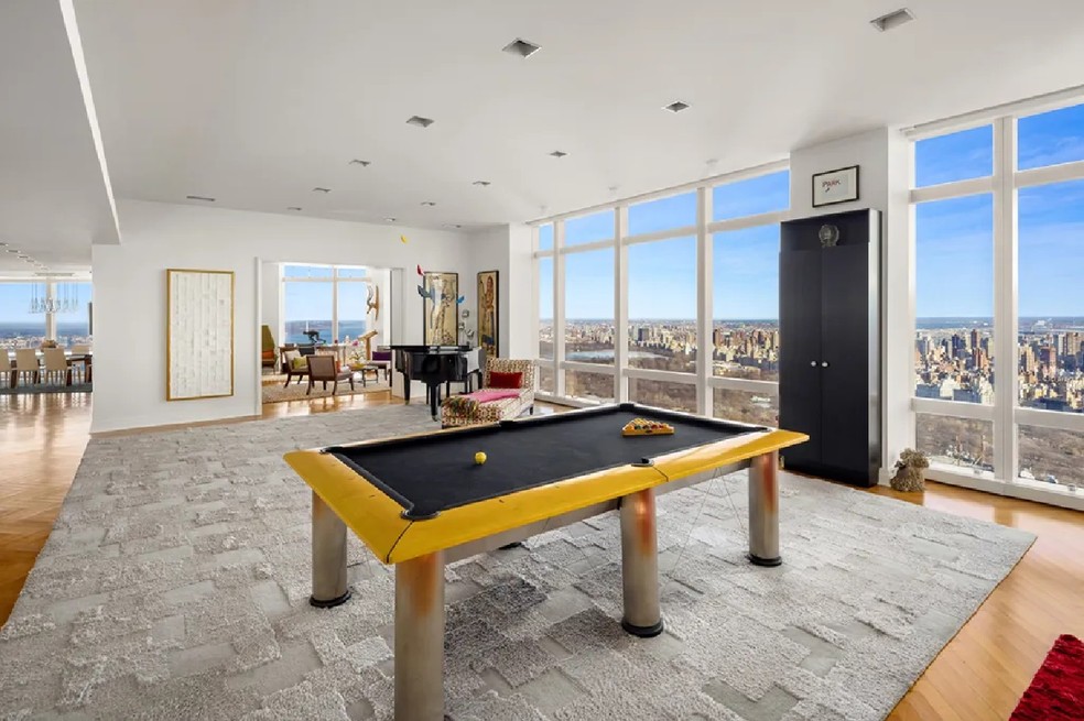 Ampla sala tem espaço para entretenimento, com mesa de sinuca e piano — Foto: Evan Joseph/Sotheby's International Realty