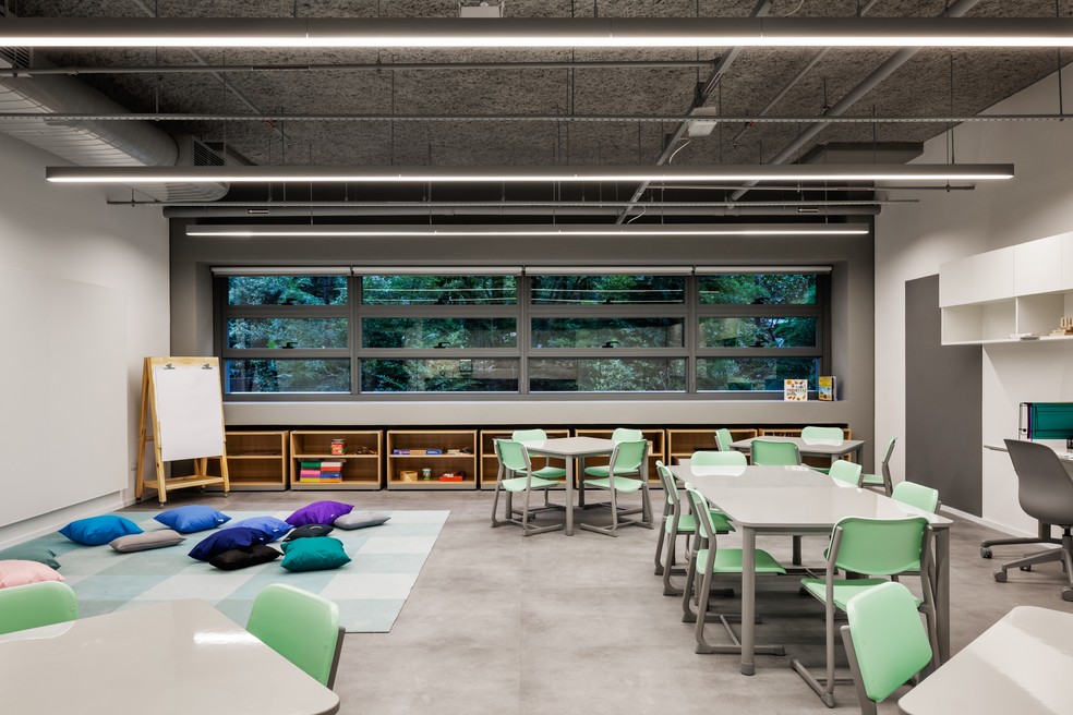 Uma das salas de aula com mesas grandes e pequenos incentivando à troca de ideias e ao protagonismo dos alunos — Foto: Ana Mello/Divulgação