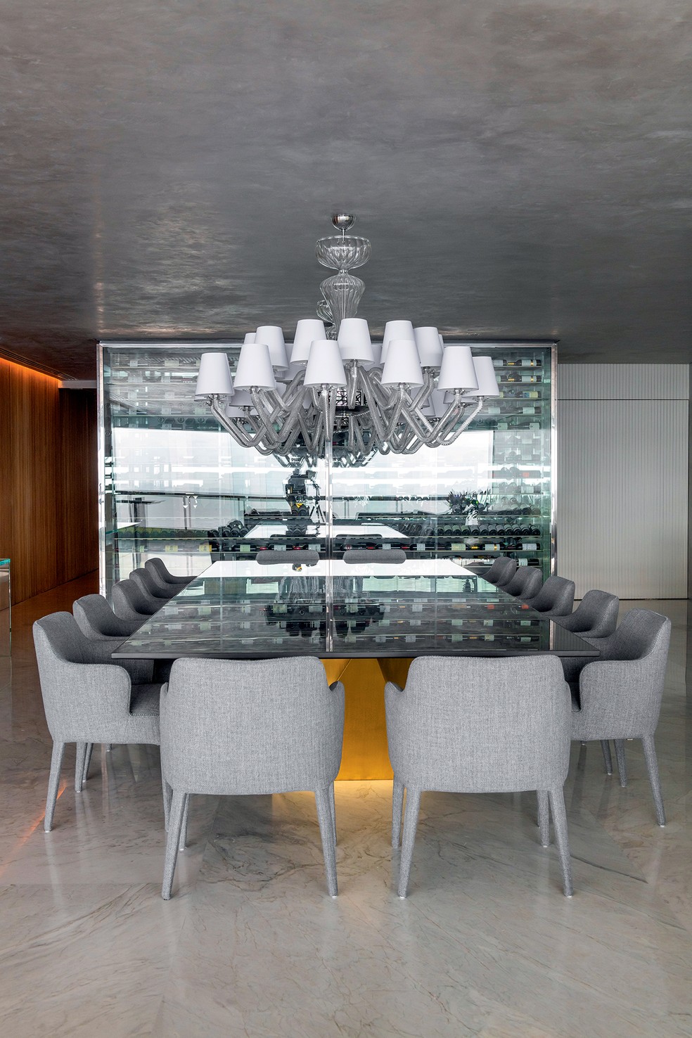 A adega,  da Joshua Adegas Climatizadas, é visualizada a partir da mesa de jantar, posicionada sob lustres de design italiano — Foto: Marcelo Negromonte