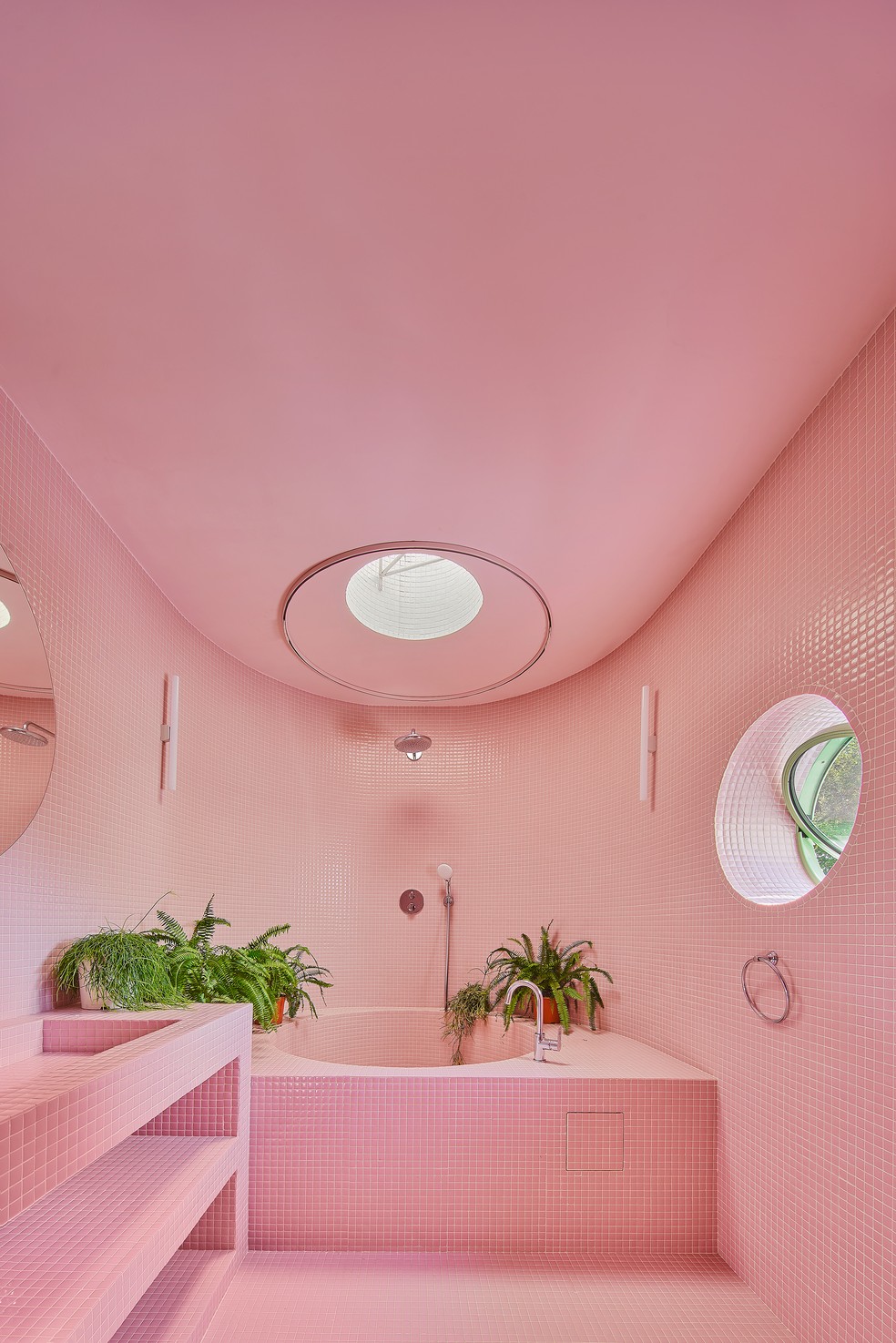No banheiro, o rosa é onipresente, por meio de azulejos e da pintura nas paredes: vai do piso ao teto, além de envolver a banheira enfeitada com samambaias. — Foto: Jose Hevia