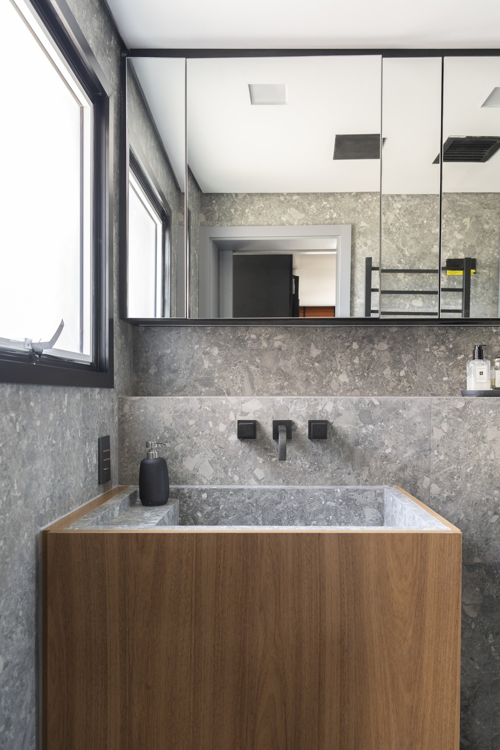 No banheiro da suíte, a arquiteta combinou porcelanato que imita concreto com madeira - reforçando o aspecto industrial do projeto — Foto: Cris Farhat
