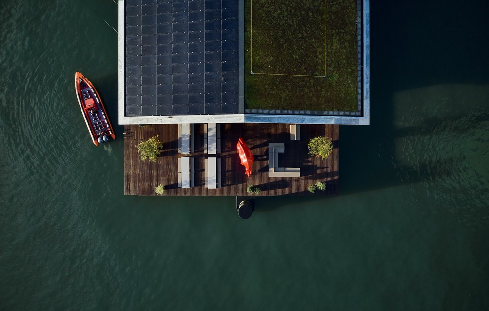 Assinada pelo estúdio holandês Powerhouse Company, a estrutura flutuante é um escritório autossuficiente em energia e neutro em carbono, localizado no porto de Rijnhaven, em Roterdã: além de uso de madeira e presença de painéis solares, a edificação tem sistema de resfriamento com água do próprio rio — Foto: Mark Seelen