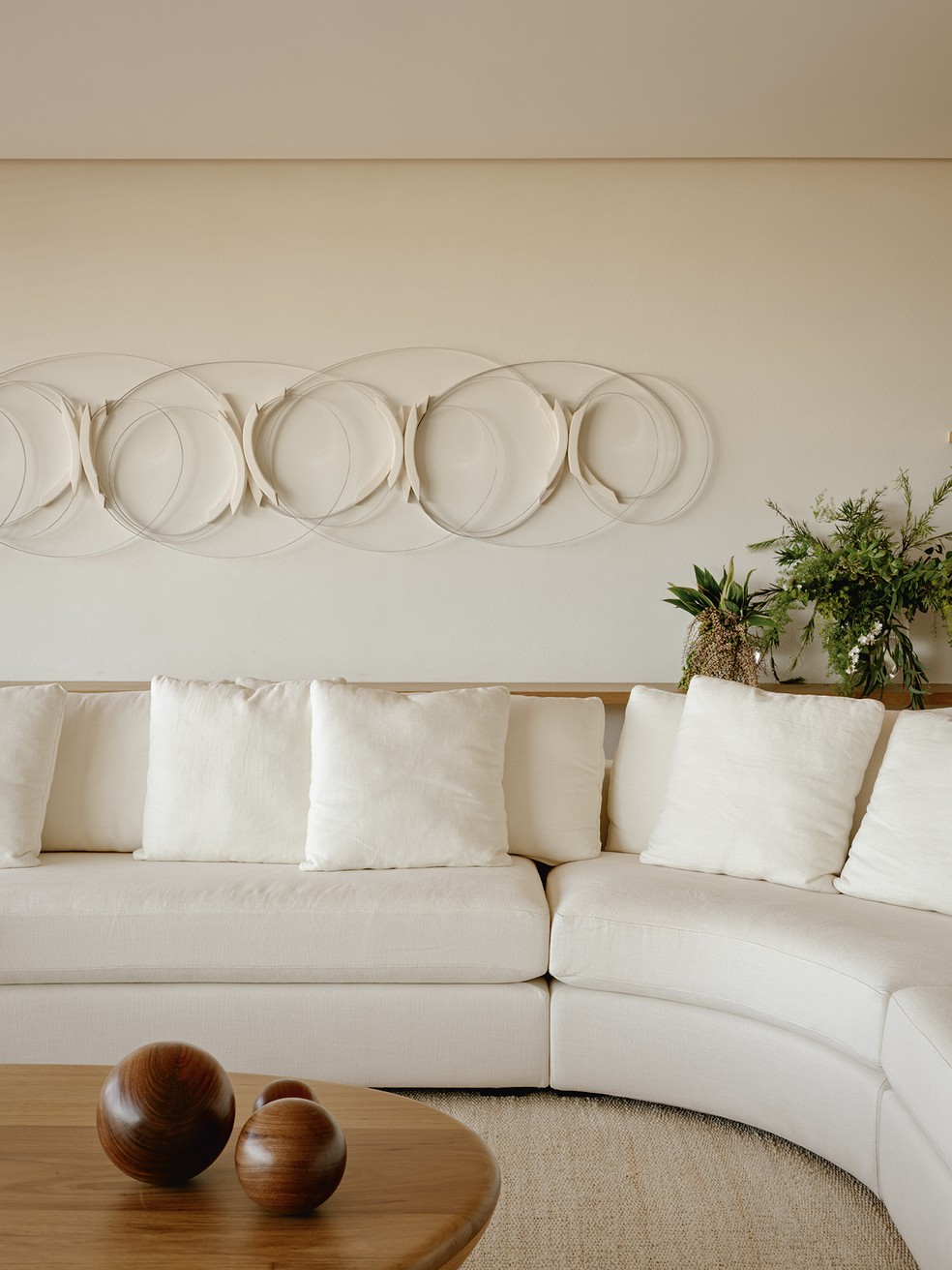 Em outro canto do living, a escultura criada por Ana Holck dialoga visualmente com a forma curva do sofá desenhado pelo Bernardes Arquitetura e com a mesa de centro Seixo, design Jacqueline terpins para o Arquivo Contemporâneo   — Foto: Fran Parente