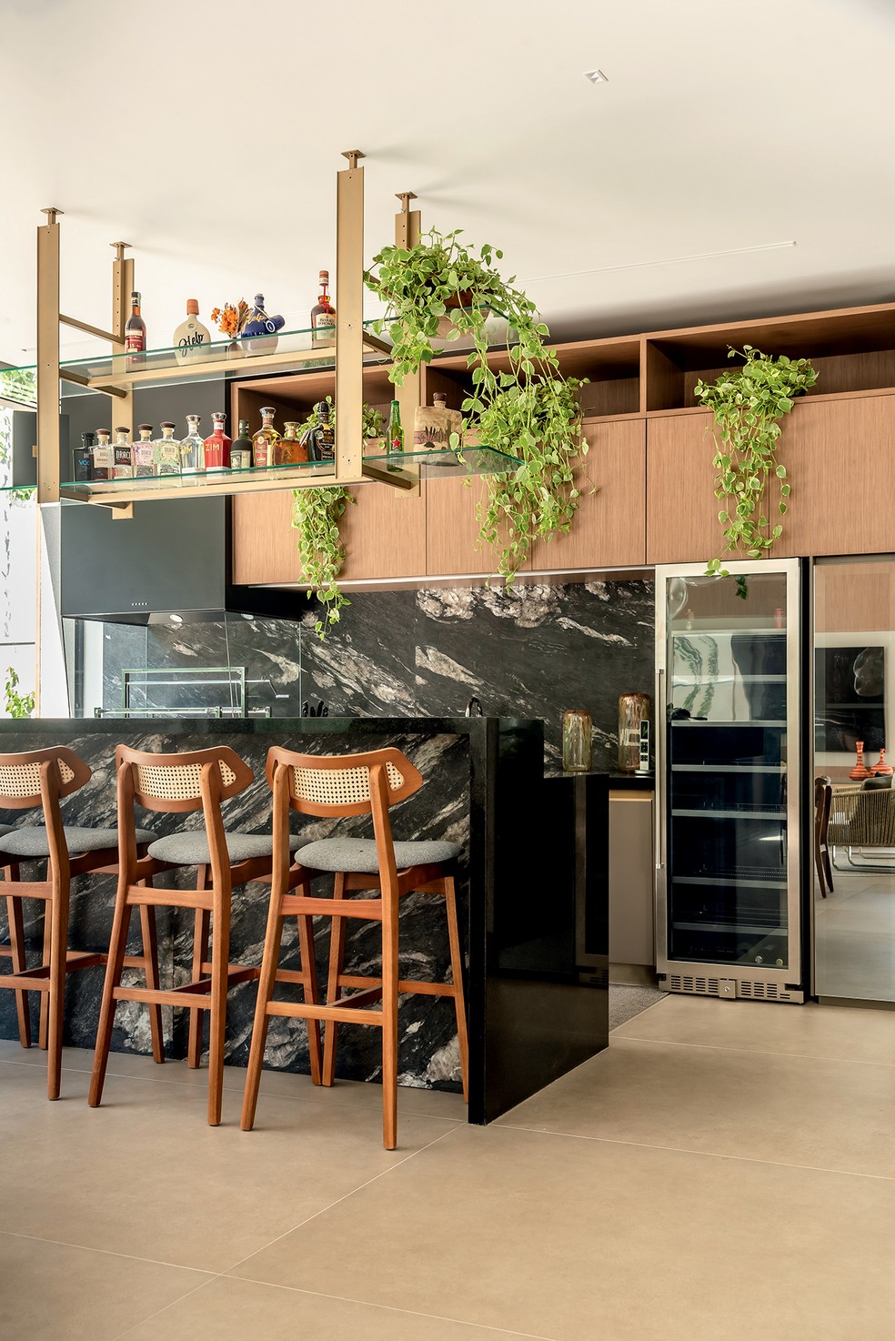 O espaço gourmet foi decorado com plantas e um bar na estante suspensa – o piso é da Staccato Revestimentos — Foto: Wesley Diego Emes