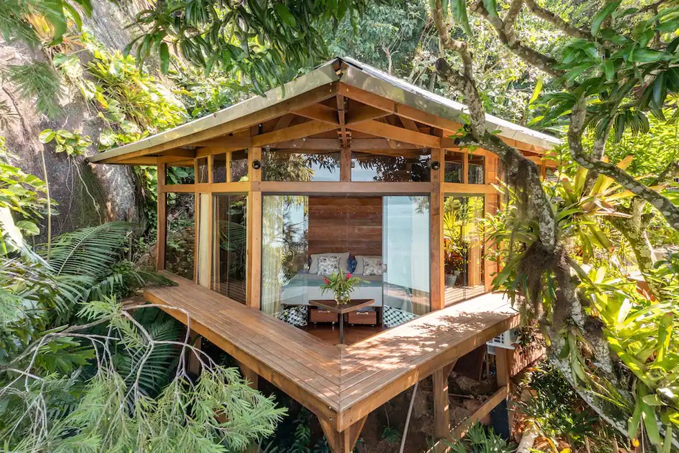 Quarto da Casa Proa, com janelas de vidro e cercado de natureza, em Paraty — Foto: Divulgação/Airbnb